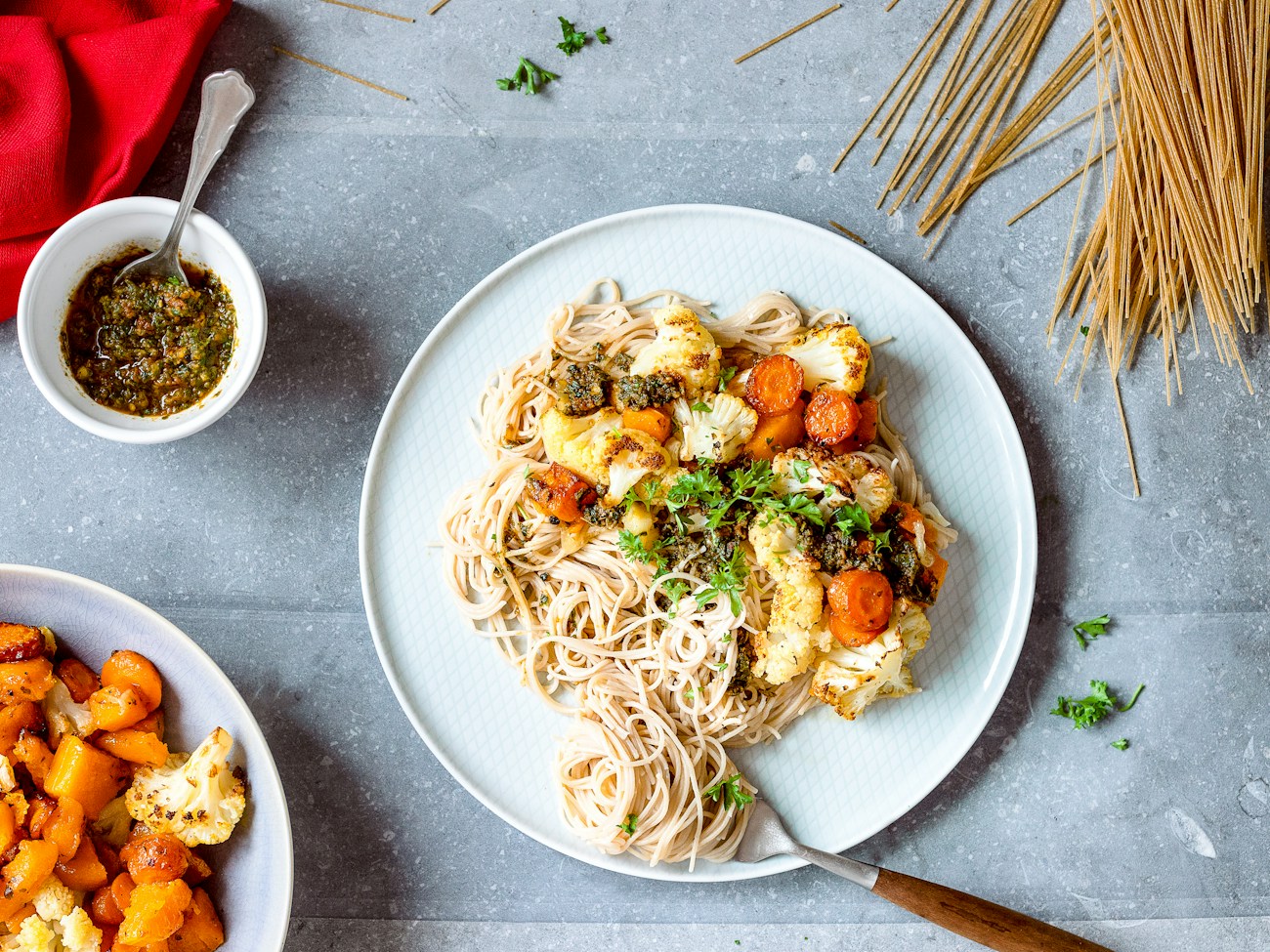 Pesto pasta topped with roasted cauliflower, squash, and fresh herbs